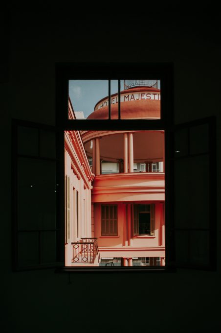 An orange painted building through a window