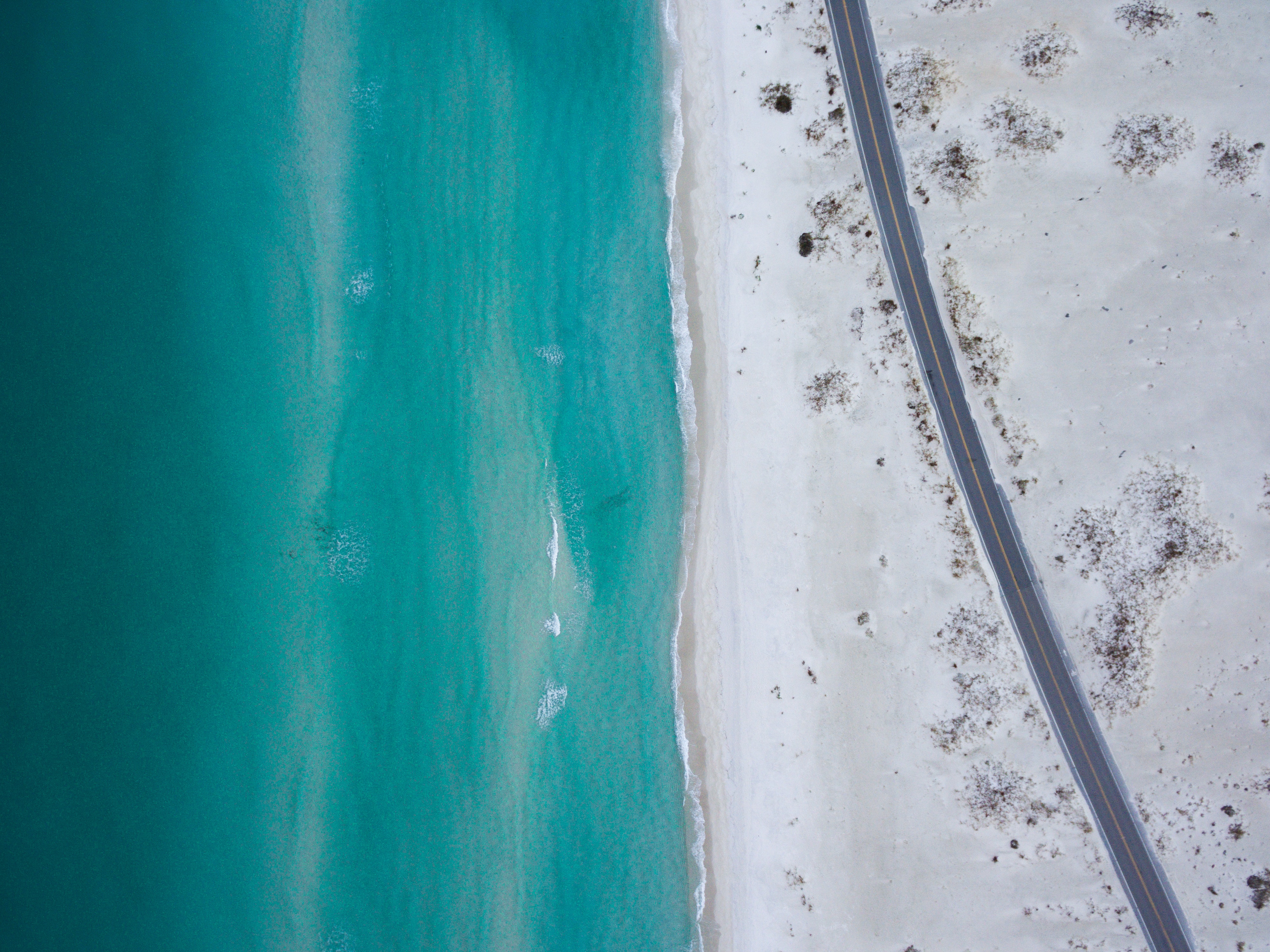Bird's eye view of a road along a beach during daytime