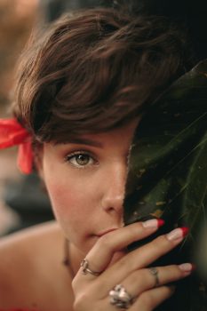 Close-up photo of a woman holding a leaf