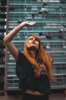 Low-angle photo of a woman raising her right hand