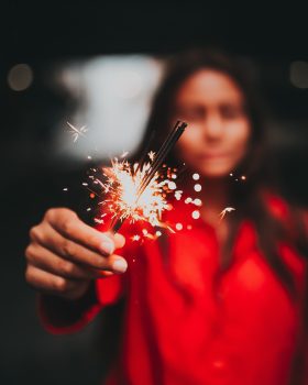 Selective focus photography of a woman holding fireworks