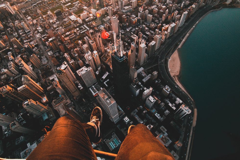 A person sitting on the roof of a skyscraper