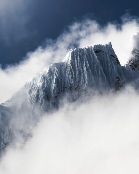 Snow-сovered mountain surrounded by clouds