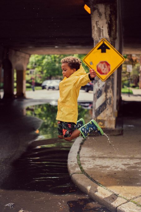 A boy jumping from the road curb