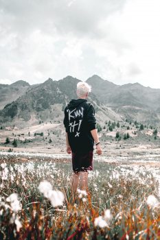 A man in a black top facing a mountain