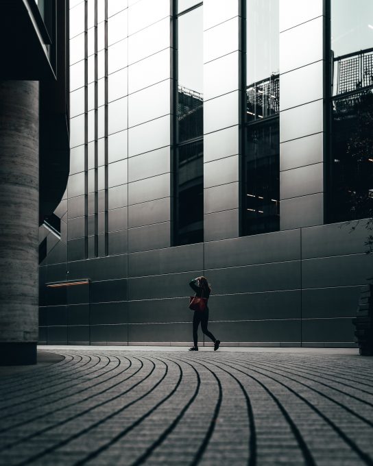 A woman walking beside a building