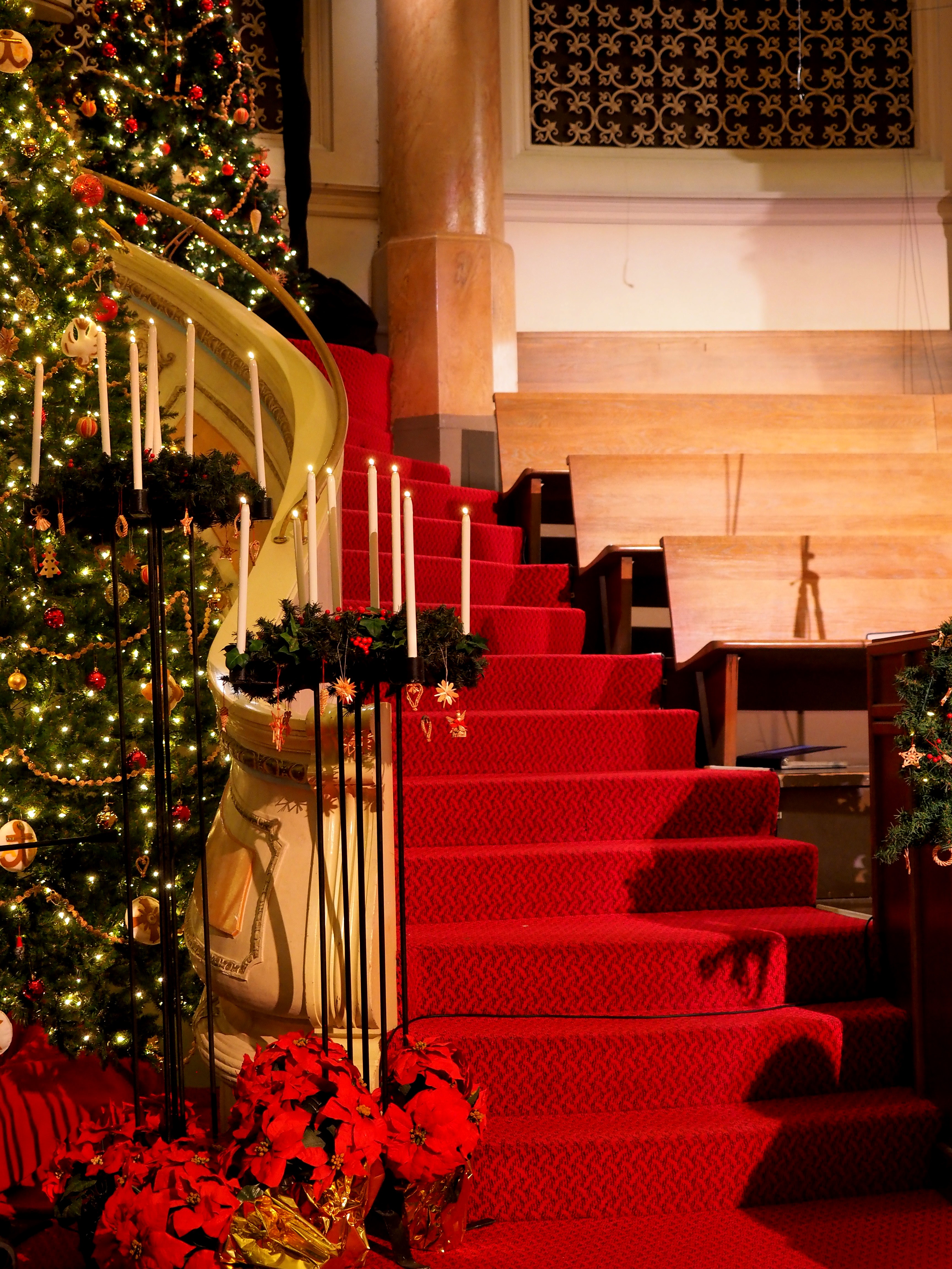 Benches beside stairs in a room decorated for Christmas