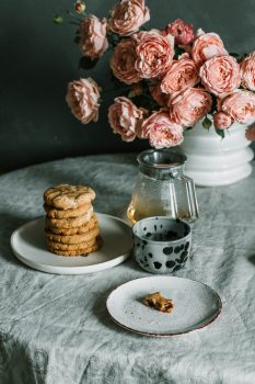 Pink flowers beside a plate of biscuits