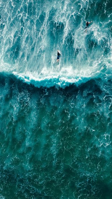 A bird's eye view of a wave and surfers