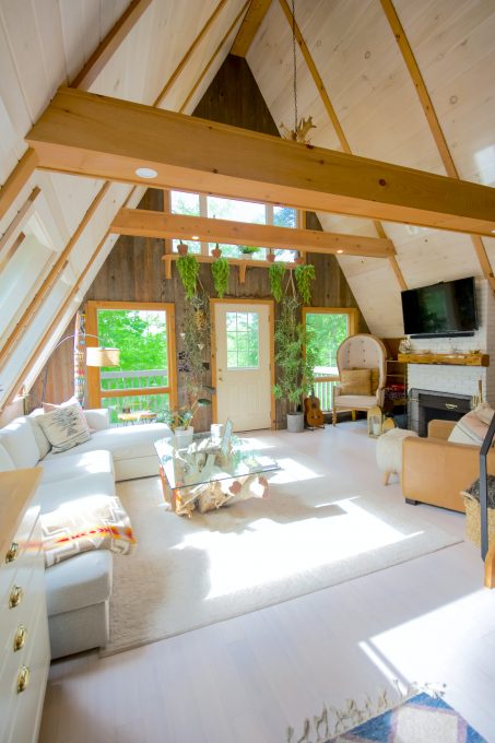 An attic living room with a couch, a tv, chairs